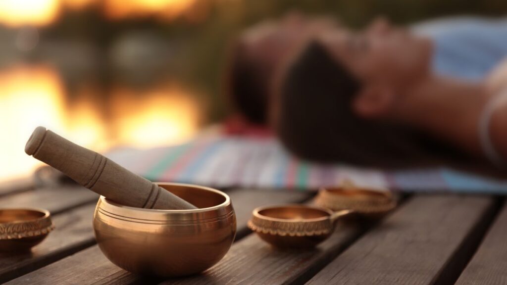 A serene image depicting Ayurvedic herbs and a practitioner guiding a meditation session.